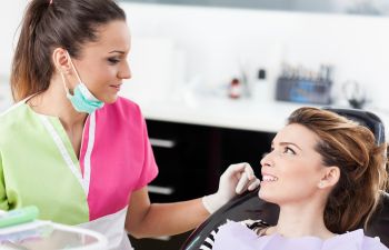 Woman in Dental Chair Talking to Hygienist