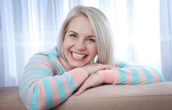 Smiling Woman Looking Over Back of Couch