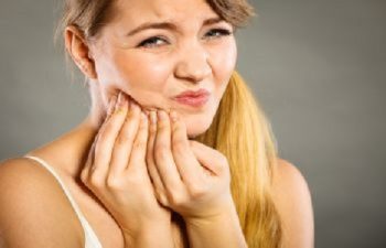 Woman with Tooth Pain Pressing Her Jaw with Hands