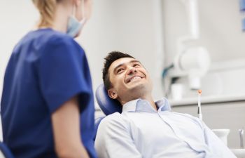 Man in Dentist Chair Smiling at Hygienist