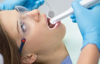 Female Patient in Dental Chair Having Gums Examined