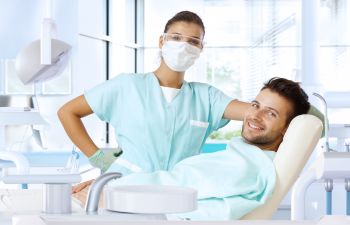 Male Patient in Dental Chair and Dental Hygienist
