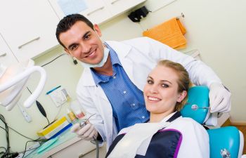 Dentist and Young Woman in Dental Chair Before Dental Procedure